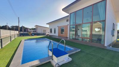Modern home exterior with swimming pool and lawn