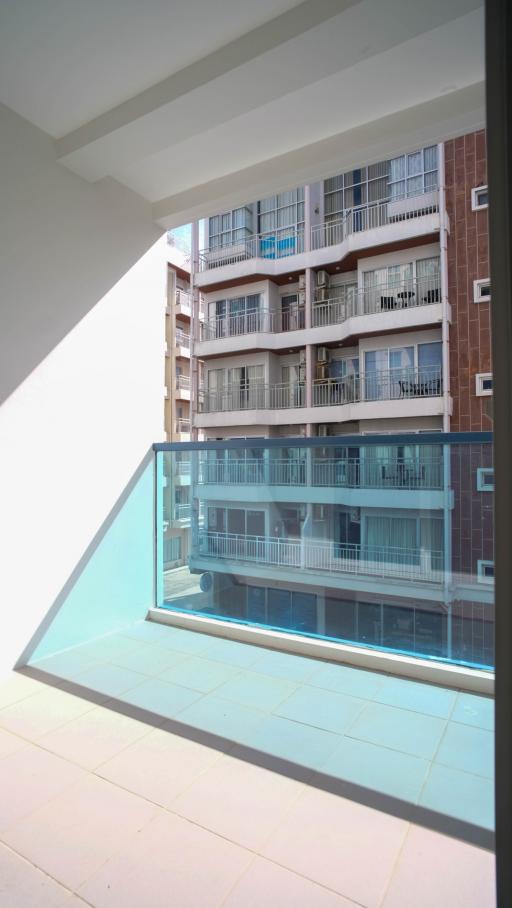 Bright balcony with glass balustrade overlooking apartment complex