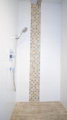 Modern white bathroom with decorative shower tiles