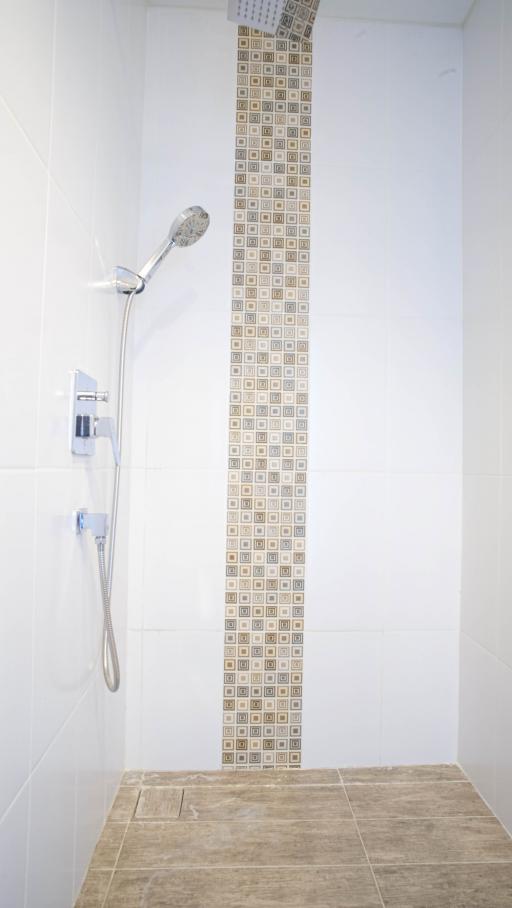 Modern white bathroom with decorative shower tiles