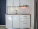 Modern kitchen with white cabinetry and under-cabinet lighting