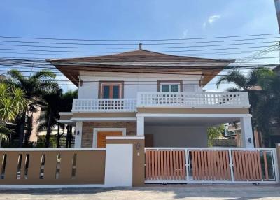 two-story residential house with balcony and front gate