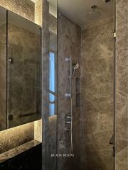 Elegant bathroom with glass shower and marble walls