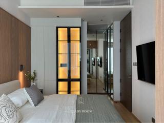 Modern bedroom with en-suite bathroom and wall-mounted TV
