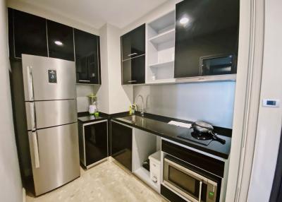 Modern kitchen with stainless steel appliances and black cabinetry