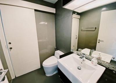 Modern bathroom with white fixtures and dark walls