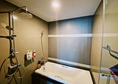 Modern bathroom with rain showerhead and well-lit vanity