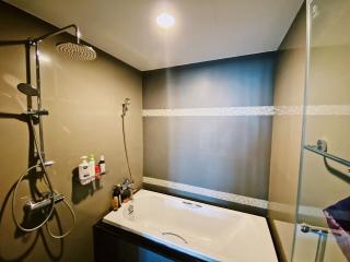 Modern bathroom with rain showerhead and well-lit vanity