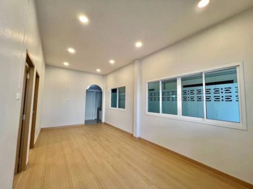 Spacious unfurnished room with hardwood flooring and natural light
