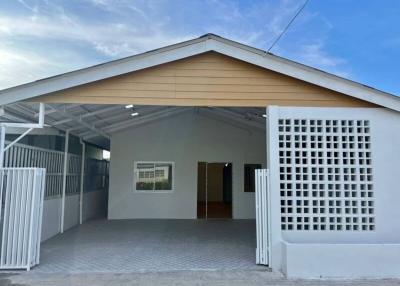 Front view of a modern house with carport and fence