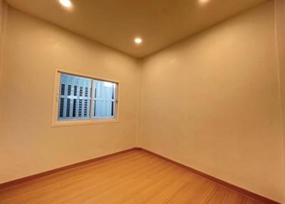 Empty bedroom with wooden flooring and a single window