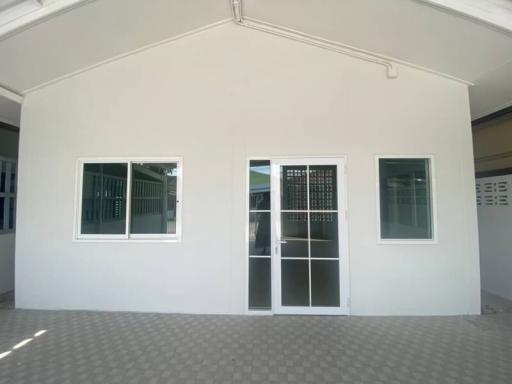 Modern exterior of a residential building with large windows and a glass door