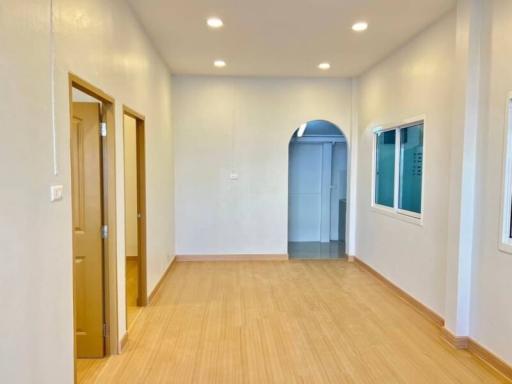 Empty bedroom with wooden flooring and ample natural light