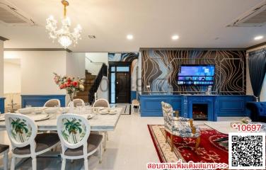 Elegant living room with dining area, modern fireplace, and staircase