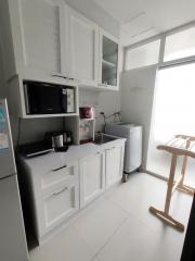 Modern compact kitchen with white cabinetry and appliances