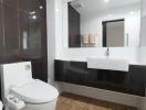 Modern bathroom with clean design, large mirror and wooden flooring