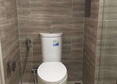 Modern bathroom with wall-mounted toilet and neutral tile design