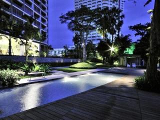 Modern residential complex with illuminated pool and garden area at night