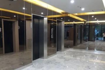 Modern elevator lobby with marble floors and mirrored walls