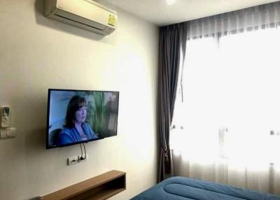 Cozy bedroom with wall-mounted TV and air conditioning unit