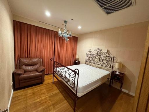 Elegant bedroom with a large bed, red curtains, and chandelier lighting