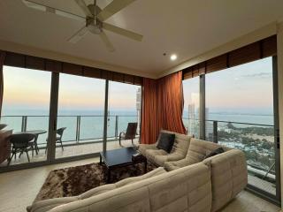 Ocean view high-rise apartment living area with ample seating and balcony