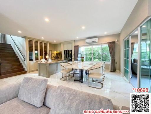 Bright and spacious living room with an open kitchen concept, modern furnishings, and large windows