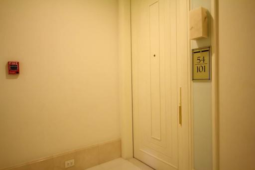 Compact entryway with neutral wall colors and fire safety equipment