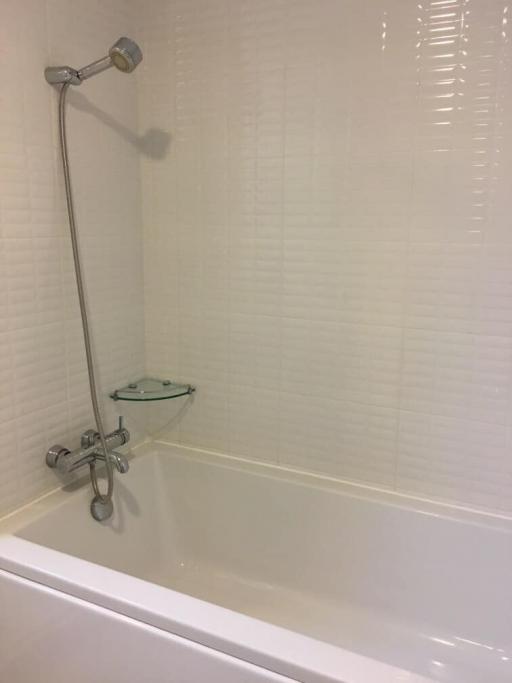 Clean white tiled bathroom with shower