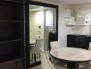 Modern dining room with white table and chairs, sliding doors leading to another room, and stylish shelving units