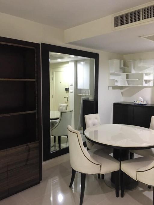 Modern dining room with white table and chairs, sliding doors leading to another room, and stylish shelving units