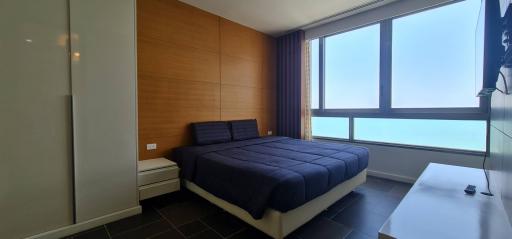 Modern bedroom with a large window and ocean view