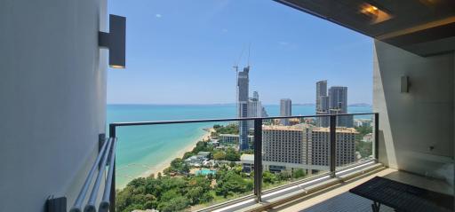 Panoramic view from the balcony showcasing the beach, sea, and cityscape