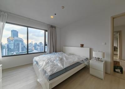 Spacious bedroom with large windows and city view