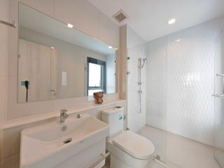 Modern white bathroom with glass shower and large mirror