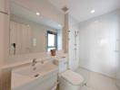 Modern white bathroom with glass shower and large mirror