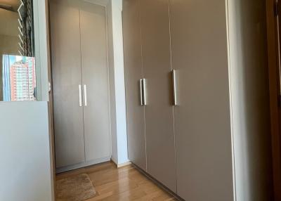 Spacious hallway with wooden flooring and built-in storage closets