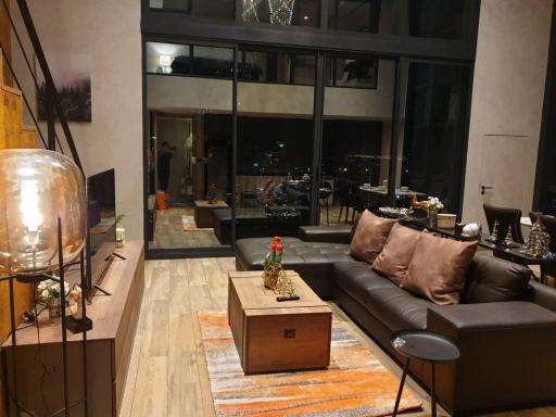 Modern living room with large windows and city view at night