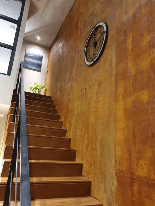 Modern staircase with wooden steps and metal railing inside a house