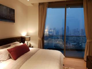 Cozy bedroom with a cityscape view through large windows