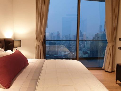 Modern bedroom with expansive city view through floor-to-ceiling windows