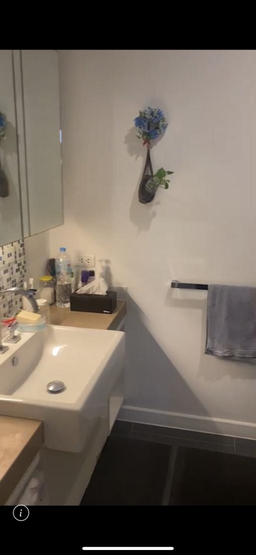 Modern bathroom interior with wall-mounted sink and decorated mirror