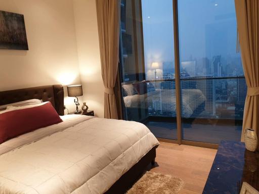Modern bedroom with large windows and city view at dusk