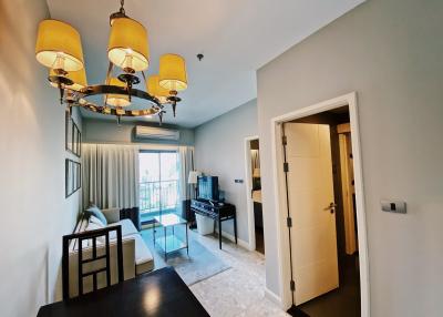 Modern entrance hall with chandelier and open door leading to living room