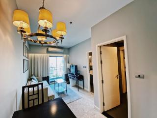 Modern entrance hall with chandelier and open door leading to living room