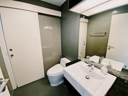 Modern bathroom with sliding door, toilet, and sink