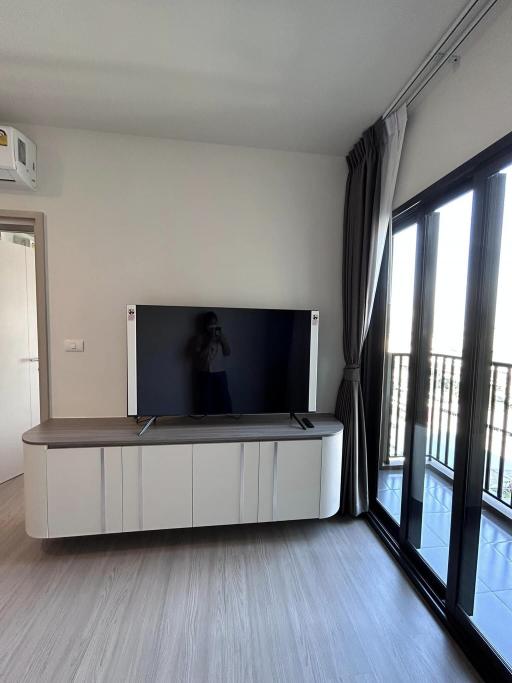 Modern living room with large TV and balcony access