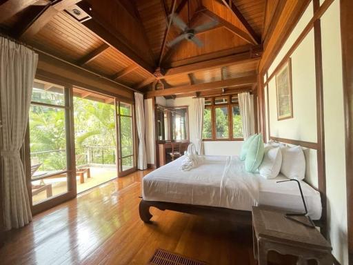 Spacious bedroom with hardwood floors and abundant natural light