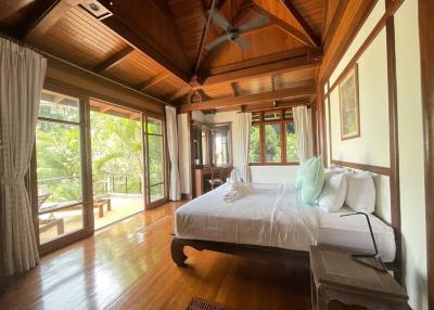 Spacious bedroom with hardwood floors and abundant natural light