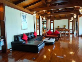 Spacious living room with wooden floors, high ceilings, and natural light